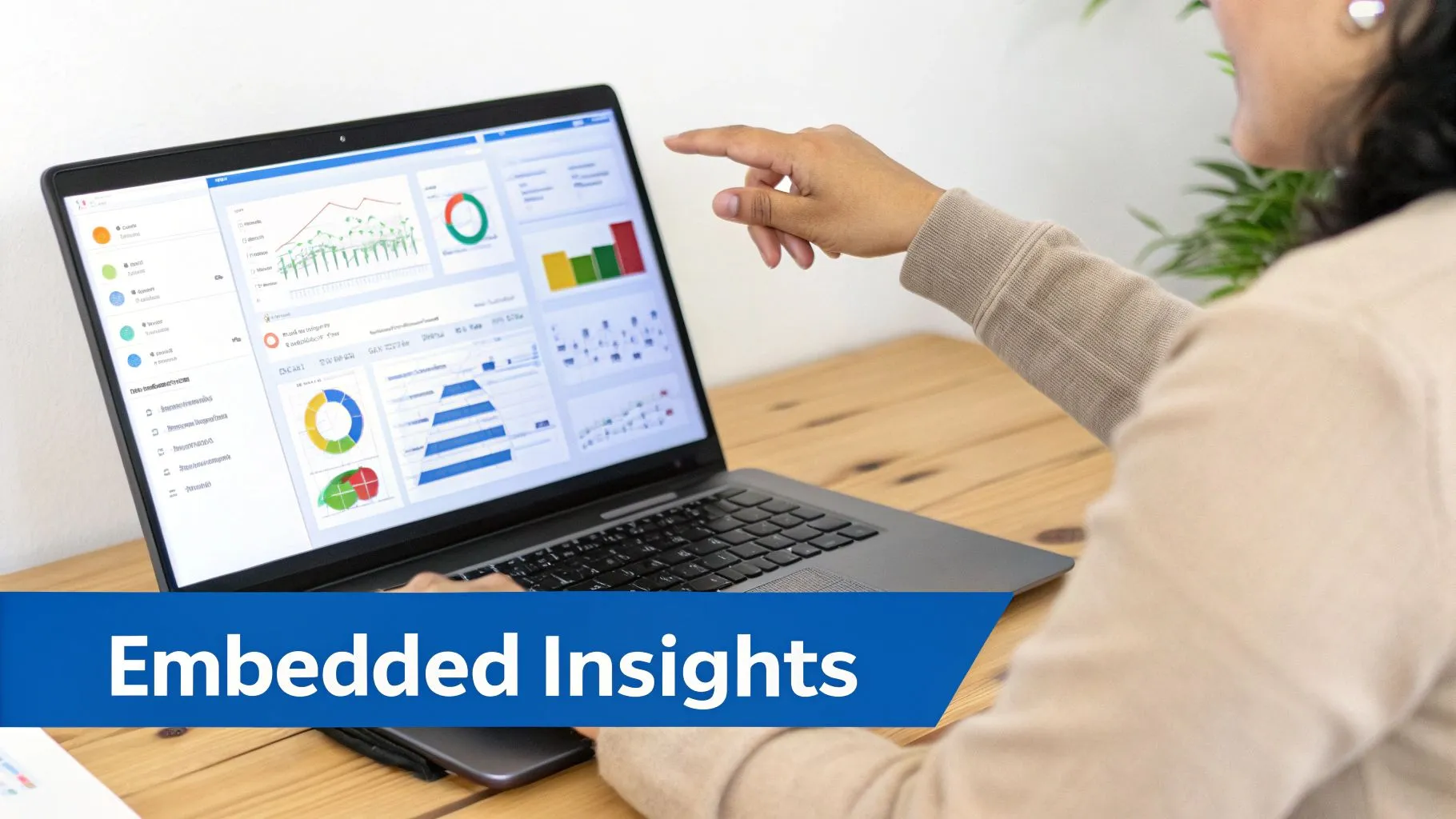 A person points at a laptop displaying a business intelligence dashboard with charts and graphs.